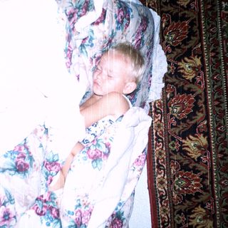 Child peacefully sleeping in floral bedding.