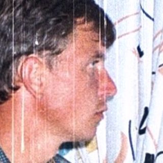 Man standing in shower with rain-like water.