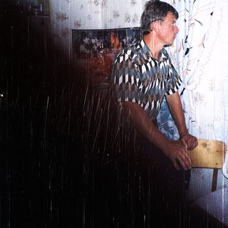 Man standing in shower with rain-like water.