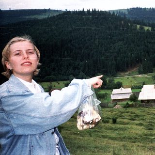 Woman pointing at scenic rural landscape with basket.