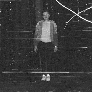 A person standing under illuminated tree branches.