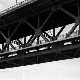 Black and white photo of steel bridge trusses.