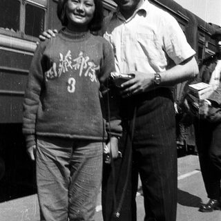 Two people posing together near a train.