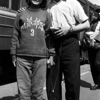 Two people posing together near a train.