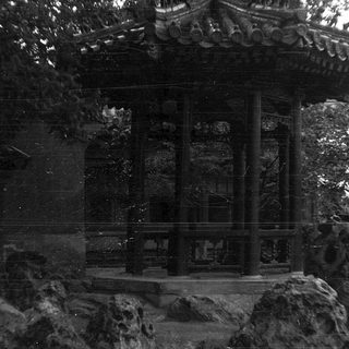 Traditional pavilion with stone base and roof.