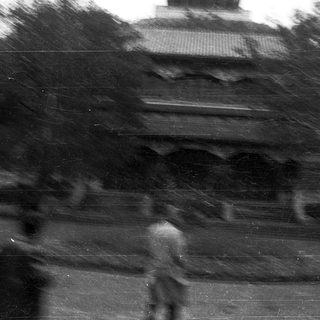 Blurred black-and-white photo of temple stairs with people.