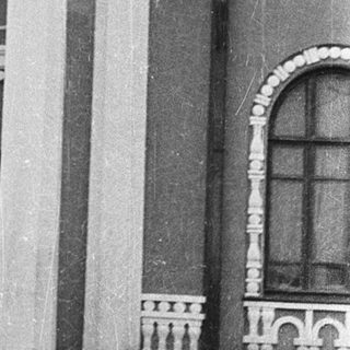Historic building entrance with two men standing.