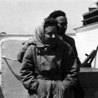 People in heavy winter clothing near a vehicle.