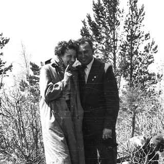 Two people posing outdoors in vintage clothing.