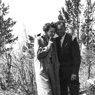 Two people posing outdoors in vintage clothing.