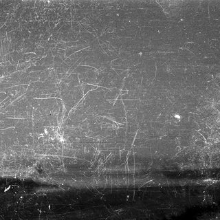 Scratched and pitted metallic surface.