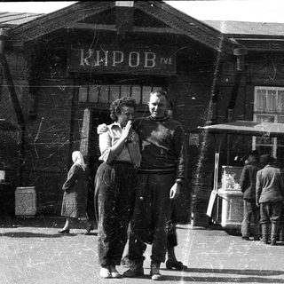 People dancing near a building labeled "Киров" in a busy outdoor setting.