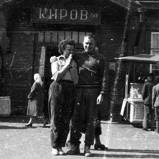 People dancing near a building labeled "Киров" in a busy outdoor setting.