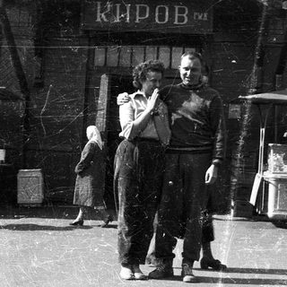 People dancing near a building labeled "Киров" in a busy outdoor setting.