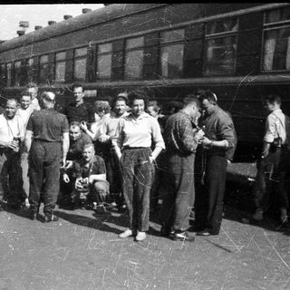 Group of people posing near a vintage train.