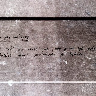 Handwritten Czech text on aged stone plaque.