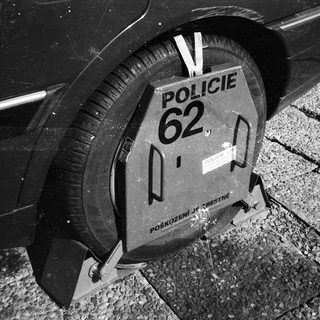 Police roadblock barrier with "Policie 62" marking.