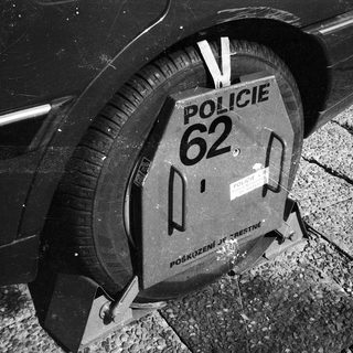 Police roadblock barrier with "Policie 62" marking.