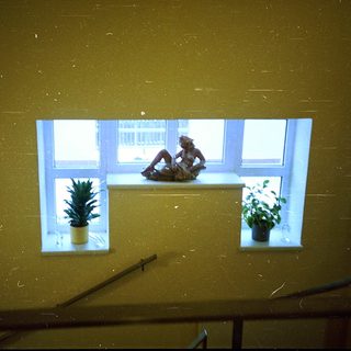 Person sitting on window sill indoors.