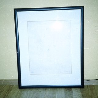 Empty framed picture on beige wall.