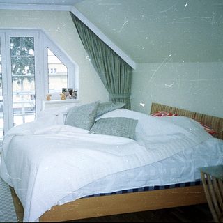 Cozy bedroom with large bed, sliding glass doors, and greenery.