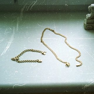 Broken jewelry on a window sill.