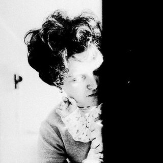 A person with voluminous hair in vintage attire.