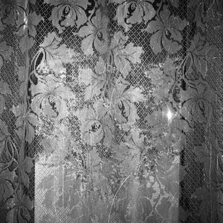 Damaged wall with floral-patterned wallpaper and blanked-out section.