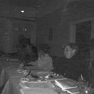 Darkly lit room with set dining table.