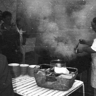 Cook preparing food in a steam-filled kitchen.