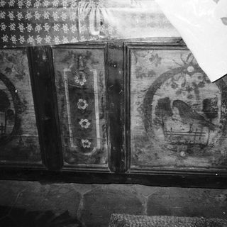 Vintage wooden cabinet with faded floral and musical designs.