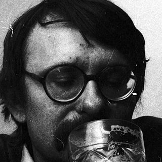 Man drinking beer indoors with glasses.