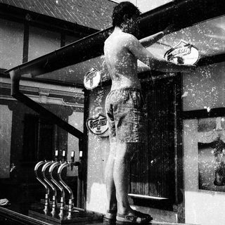 Showering man in vintage outdoor bathtub setup.