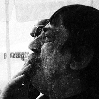 Man smoking outdoors at an outdoor café.