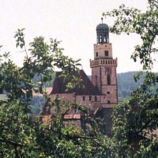 Rural scene with castle tower behind trees.