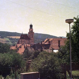 Rural town with castle and green hills.