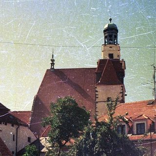 Historic European town with medieval rooftops and tower.