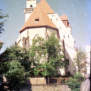Historic castle with conical tower and red roof.