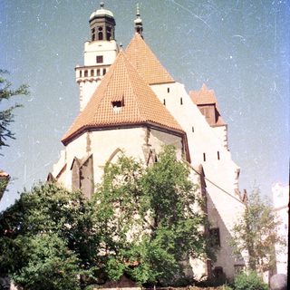 Historic castle with conical tower and red roof.