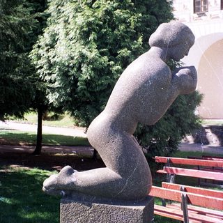Modern abstract sculpture of seated human figure.
