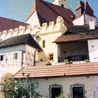 Medieval-style castle with red-tiled roofs and towers.