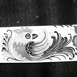 Elegant black-and-white decorative tile featuring peacock motif.