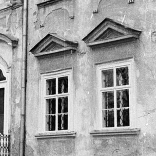 Neoclassical building with arched windows and balcony.