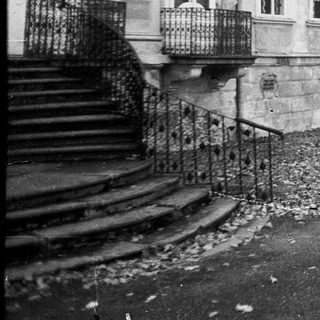 Neoclassical building exterior with stone steps.