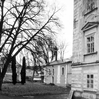 Historic building with aged stone walls and bare trees.