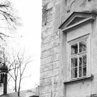 Historic building with aged stone walls and bare trees.