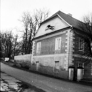 Two-story building with weathered facade on wet street.