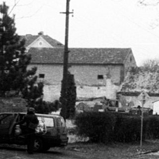 Quiet rural road with stone wall, sparse traffic.