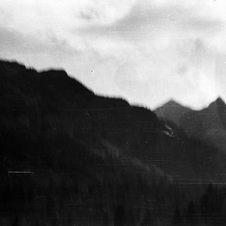 Misty mountain range with dense forest.