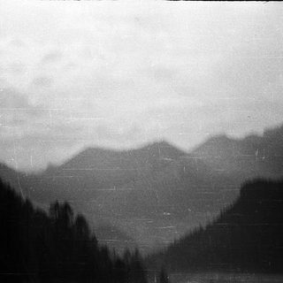 Misty mountain range with dense forest.